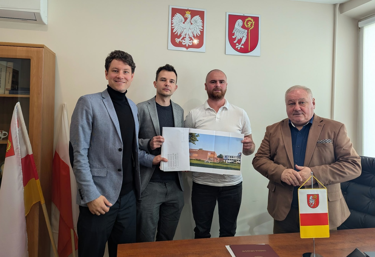 Zdjęcie: projekt sali gimnastycznej w&nbsp;Złochowicach prezentują obok w&oacute;jta Gminy Opat&oacute;w - Zdzisława Maklesa, architekci &ndash; Piotr Nowicki i&nbsp;Wojciech Machnik oraz&nbsp;społeczny pełnomocnik Gminy Opat&oacute;w ds. budowy sali gimnastycznej w&nbsp;Złochowicach &ndash; Artur Żurek