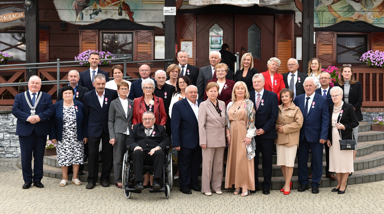 Zdjęcie grupowe 13 par, mieszkańc&oacute;w Gminy Opat&oacute;w, kt&oacute;re obchodziły jubileusz 50-lecia pożycia małżeńskiego
